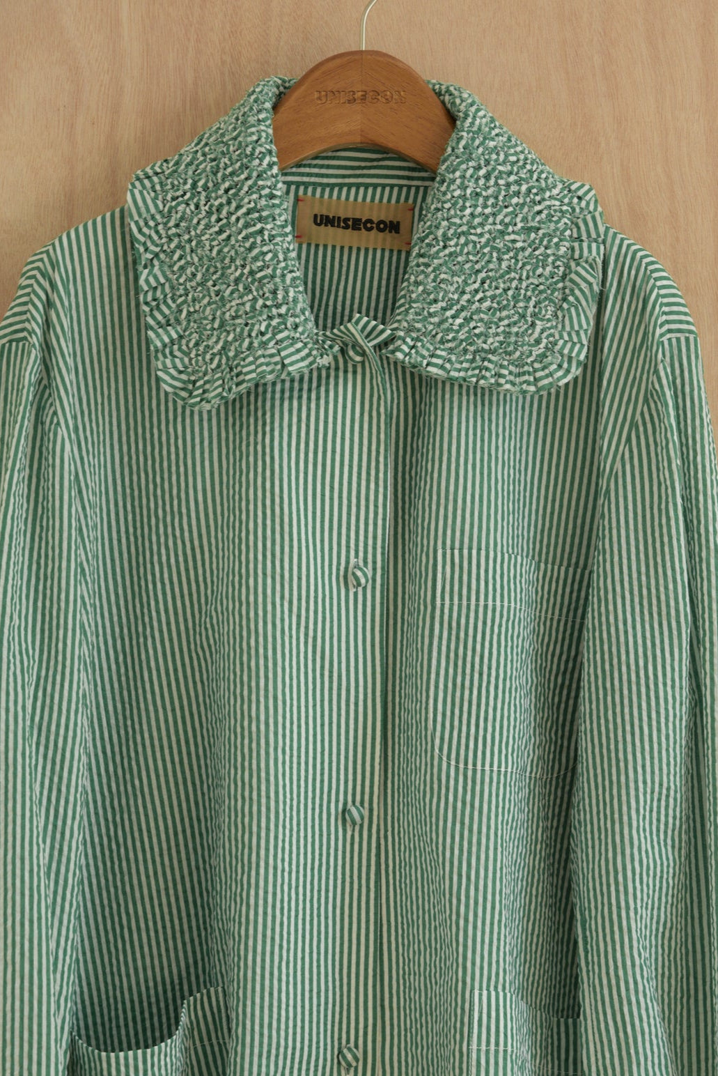 Close-up of hand-sewn sculpted collar in textured green organic cotton
