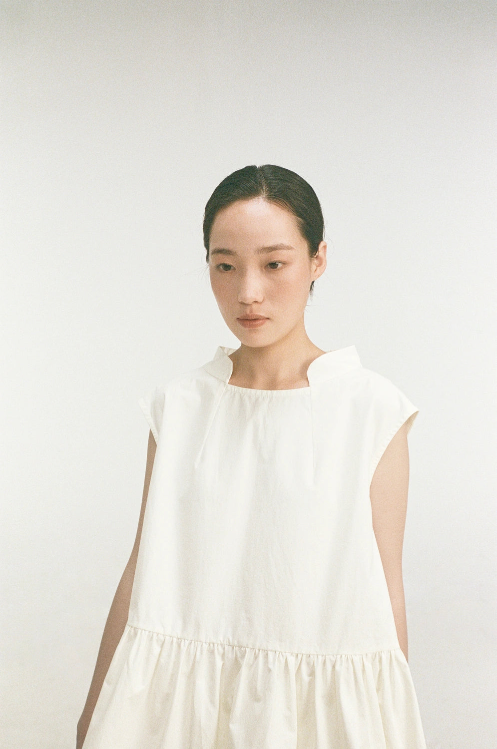 model wearing oryn top organic cotton gathered sleeveless top close up view