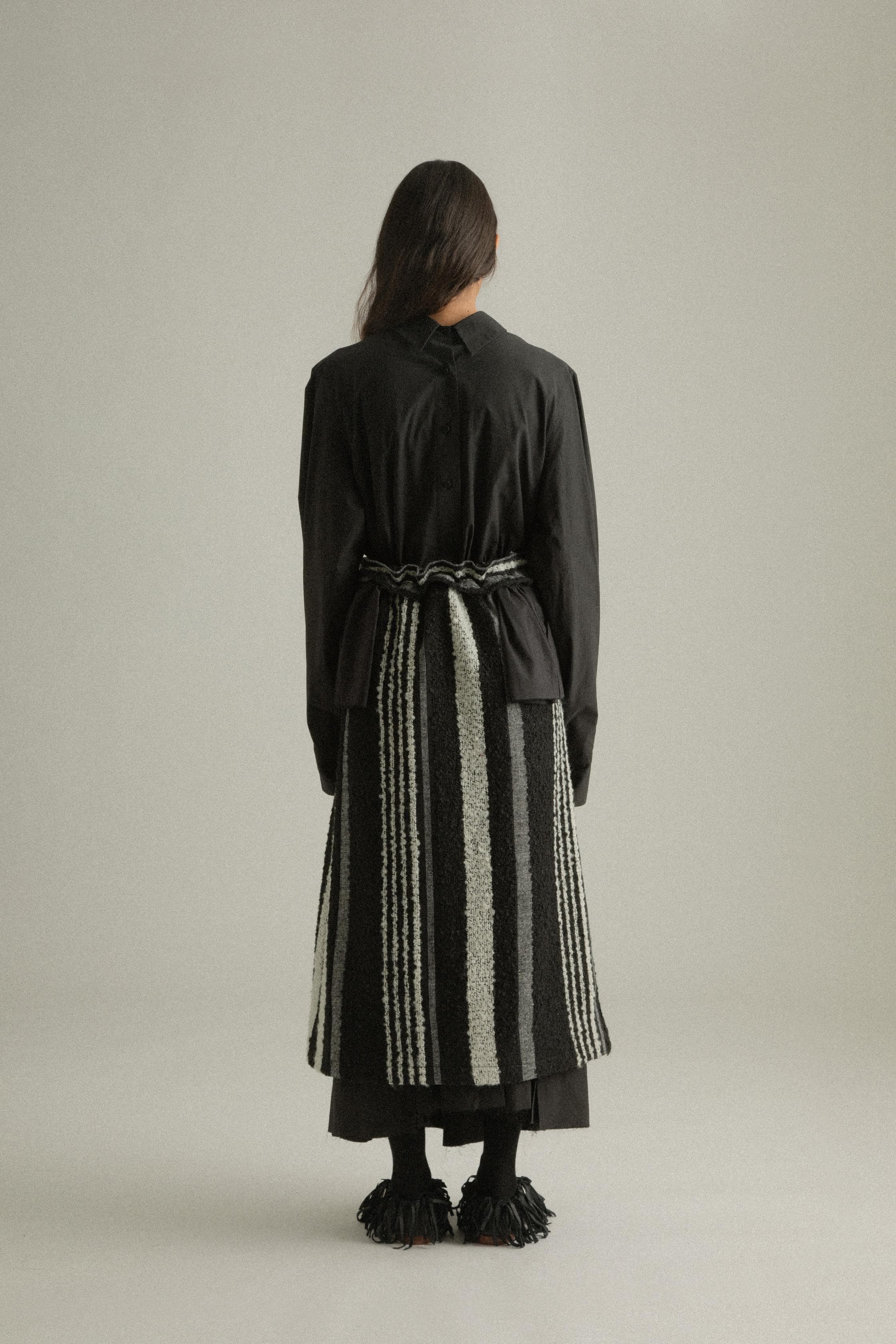 A model wearing the Farah Skirt, made from a blend of mohair and wool. The skirt features an A-line silhouette with handwoven details and is styled with the Bing Top for a cohesive look. The model is shown in front, side, and back views to highlight the skirt’s texture and fit.