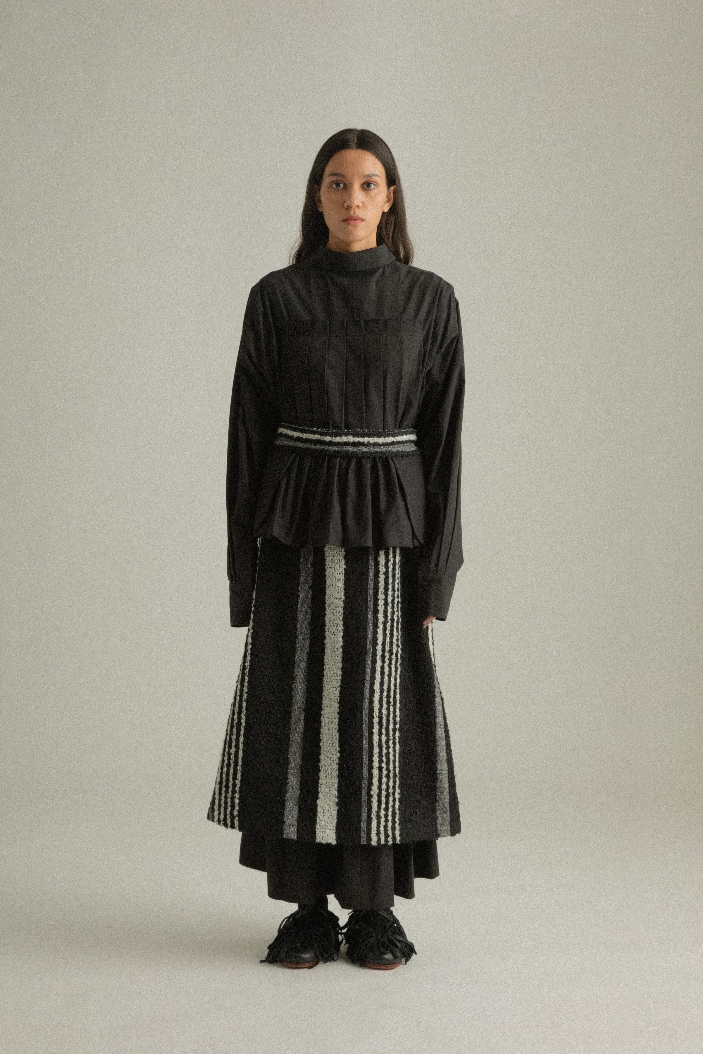 A model wearing the Farah Skirt, made from a blend of mohair and wool. The skirt features an A-line silhouette with handwoven details and is styled with the Bing Top for a cohesive look. The model is shown in front, side, and back views to highlight the skirt’s texture and fit.