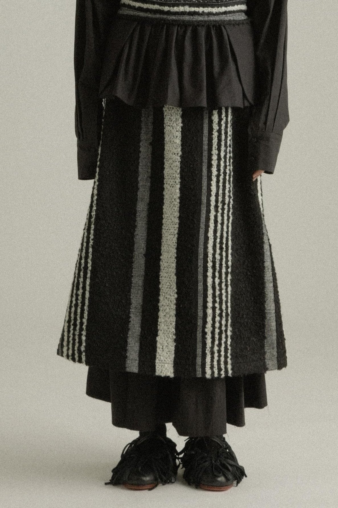 A model wearing the Farah Skirt, made from a blend of mohair and wool. The skirt features an A-line silhouette with handwoven details and is styled with the Bing Top for a cohesive look. The model is shown in front, side, and back views to highlight the skirt’s texture and fit.