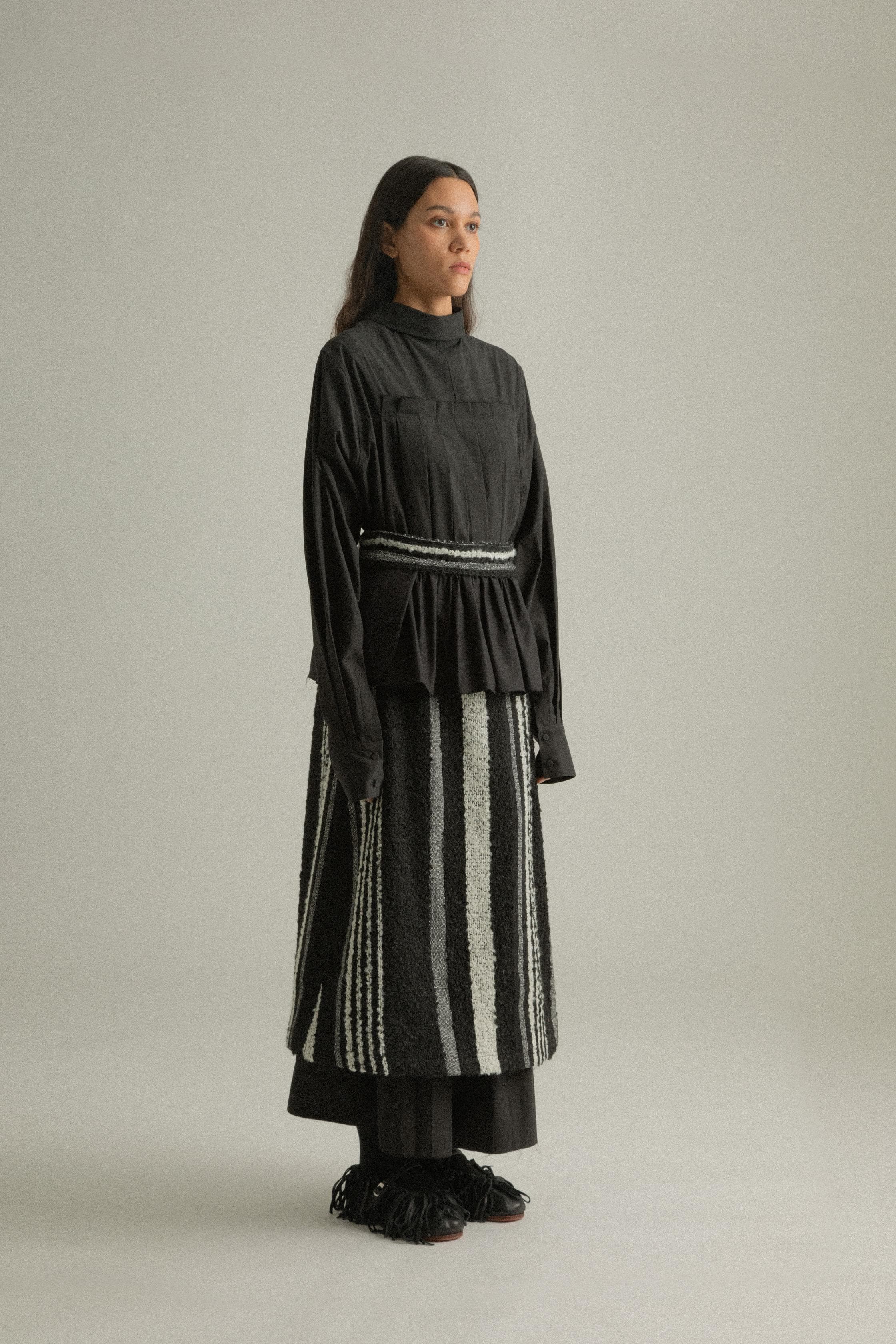 A model wearing the Farah Skirt, made from a blend of mohair and wool. The skirt features an A-line silhouette with handwoven details and is styled with the Bing Top for a cohesive look. The model is shown in front, side, and back views to highlight the skirt’s texture and fit.