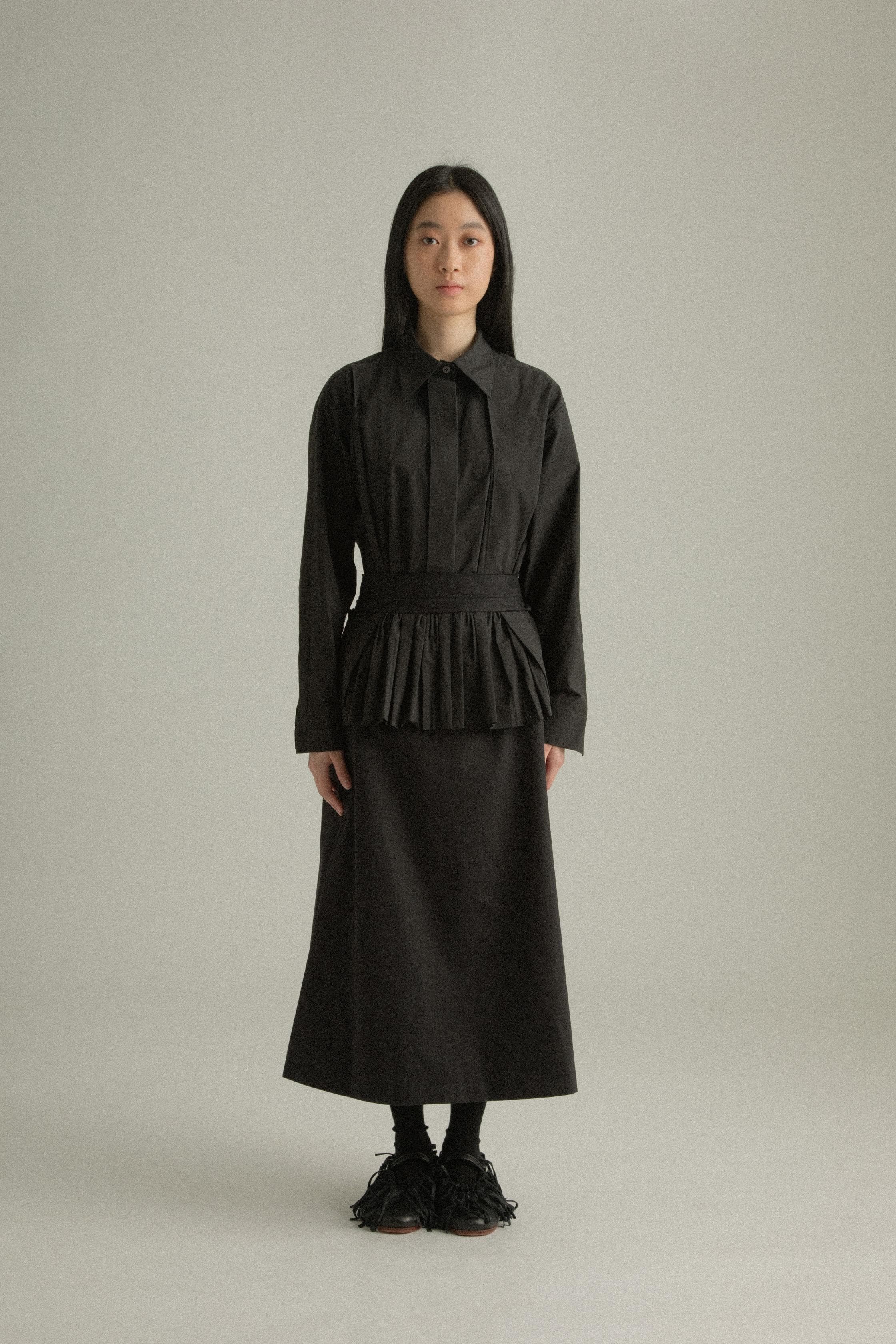 A model wearing the Farah Skirt, made from 100% organic cotton. The skirt features an A-line silhouette with handwoven patchwork and is styled with the Bing Top for a cohesive look. The model is shown in front, side, and back views to highlight the skirt’s texture and fit.