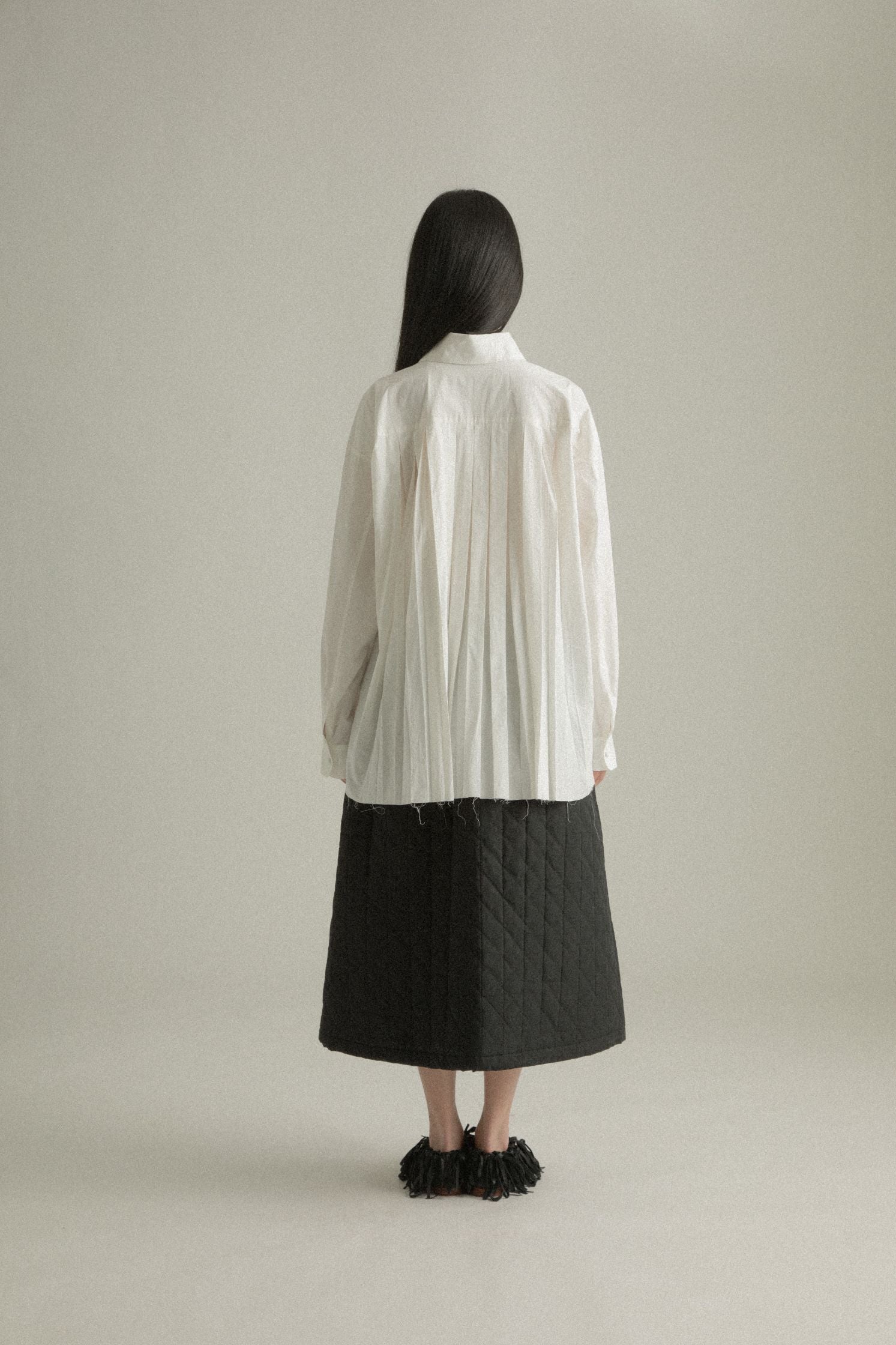  Back view of the Harvey Shirt, emphasizing the signature pleated detail in the rear.