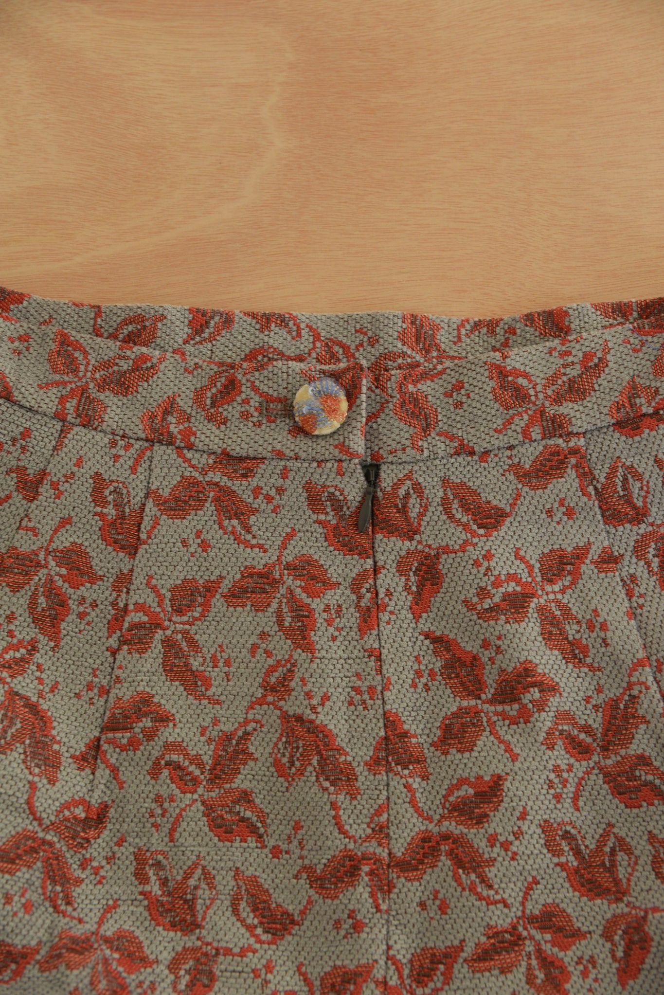 Close-up of the button closure and fabric texture of the Lola Skirt in red.