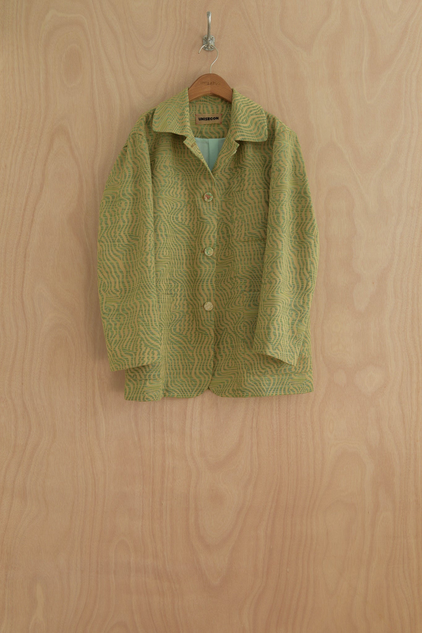 Nicole Jacket in Green, showing structured collar and button detailing.