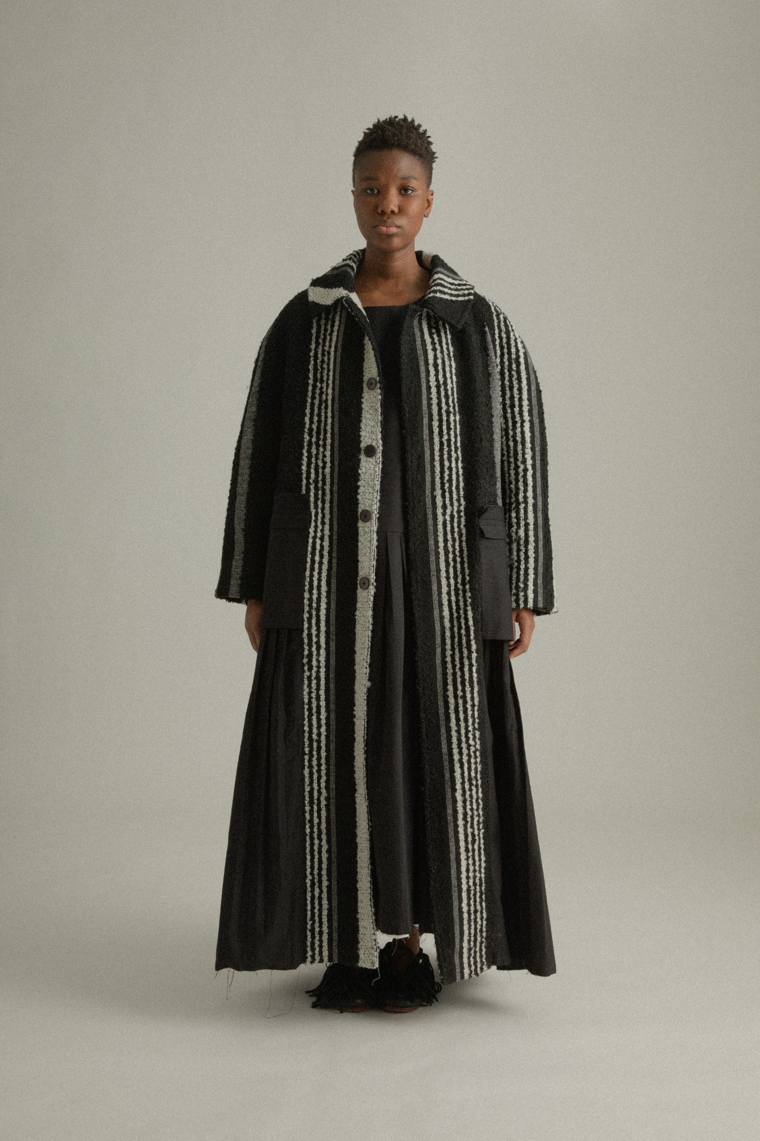 A front full body view of the Nino Coat showcasing sharp shoulders, oversized patch pockets, and its high-relief handwoven mohair texture.