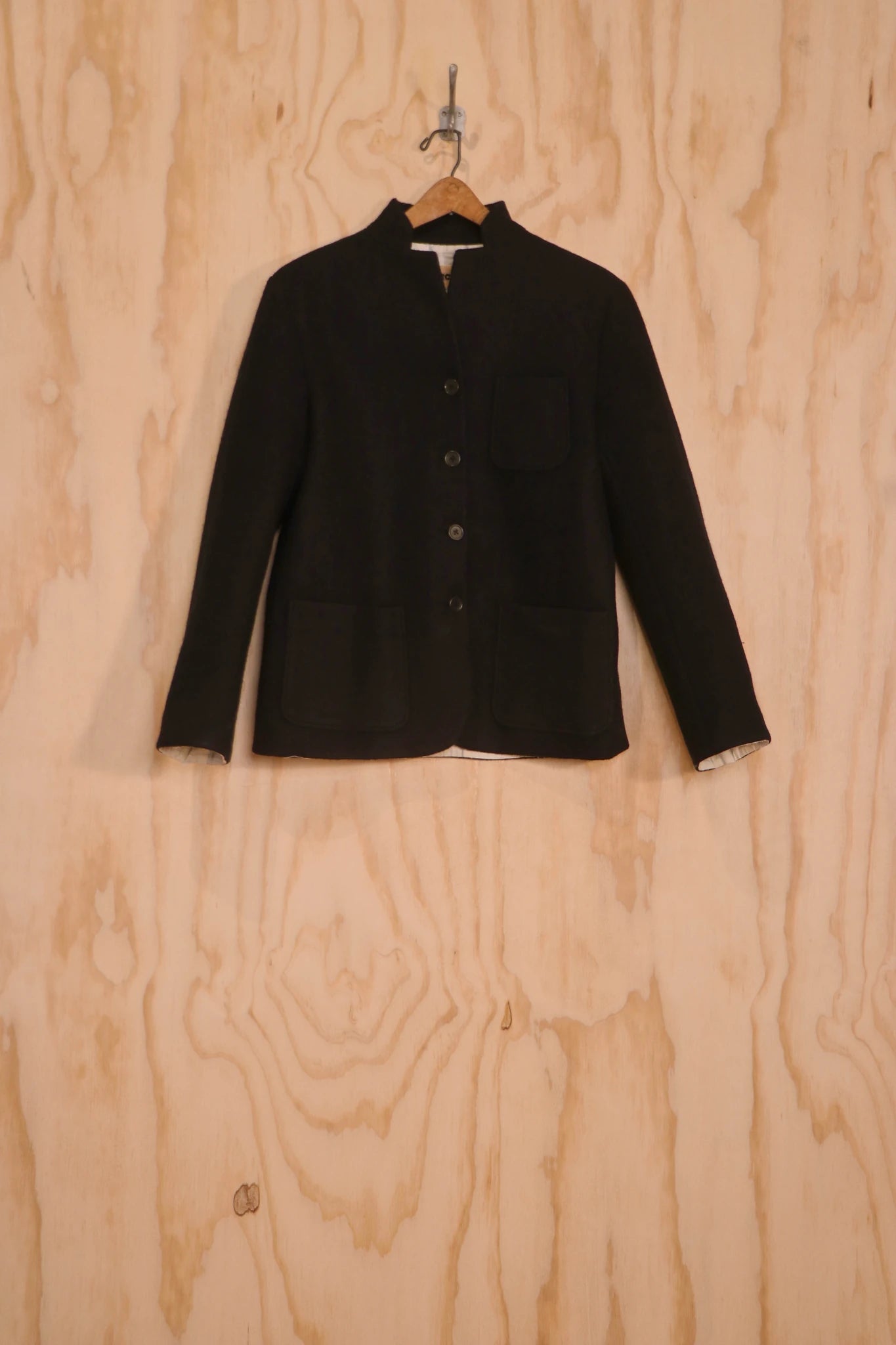 ront view of Patcha Jacket, black wool–cotton side with stand collar