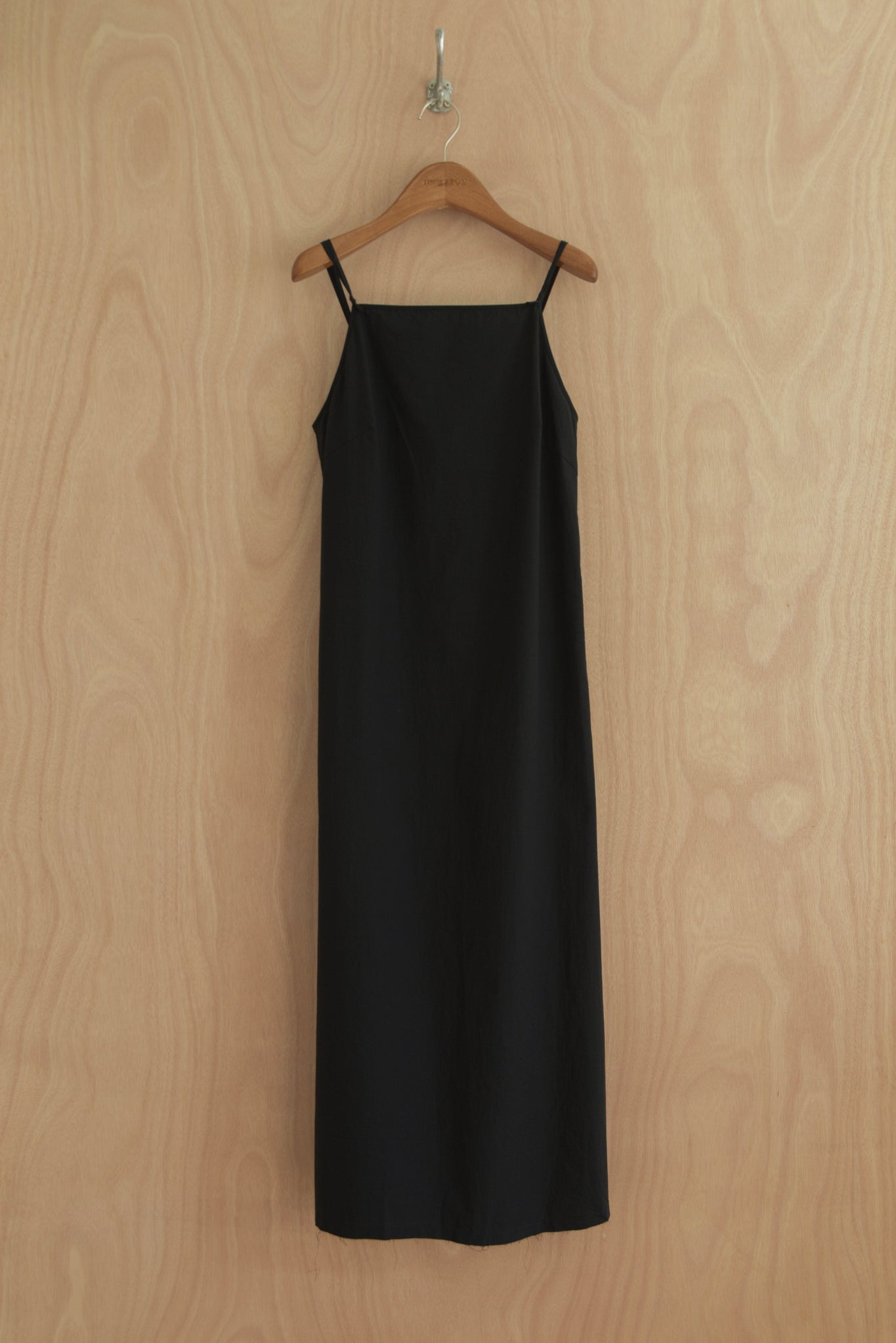 Front view of Paula Dress in black organic cotton with straight cut and thin straps