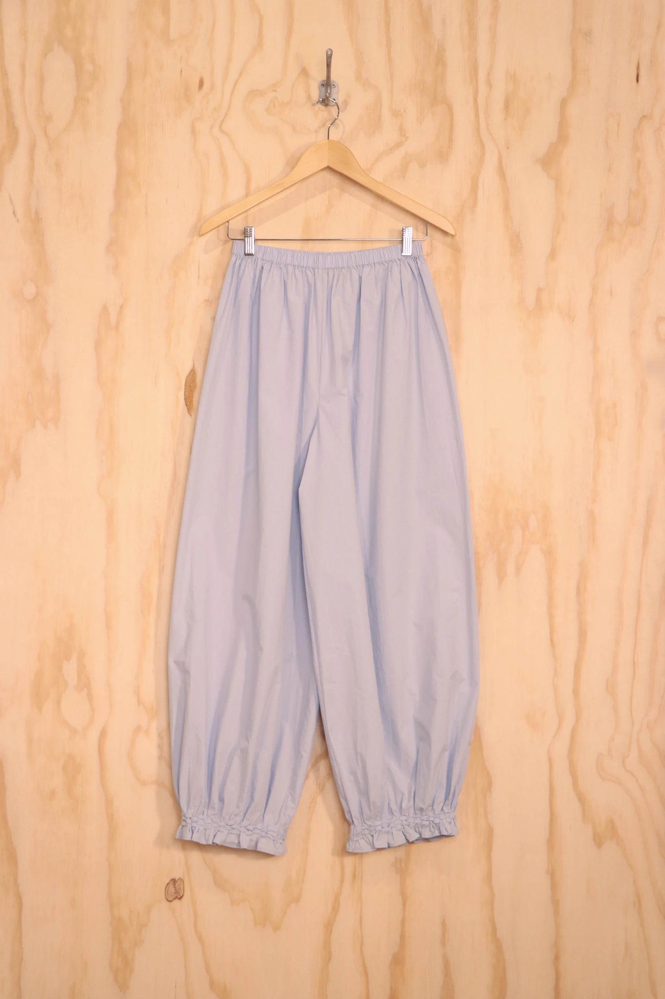 Front view of Qira Pants in light blue organic cotton with lantern silhouette