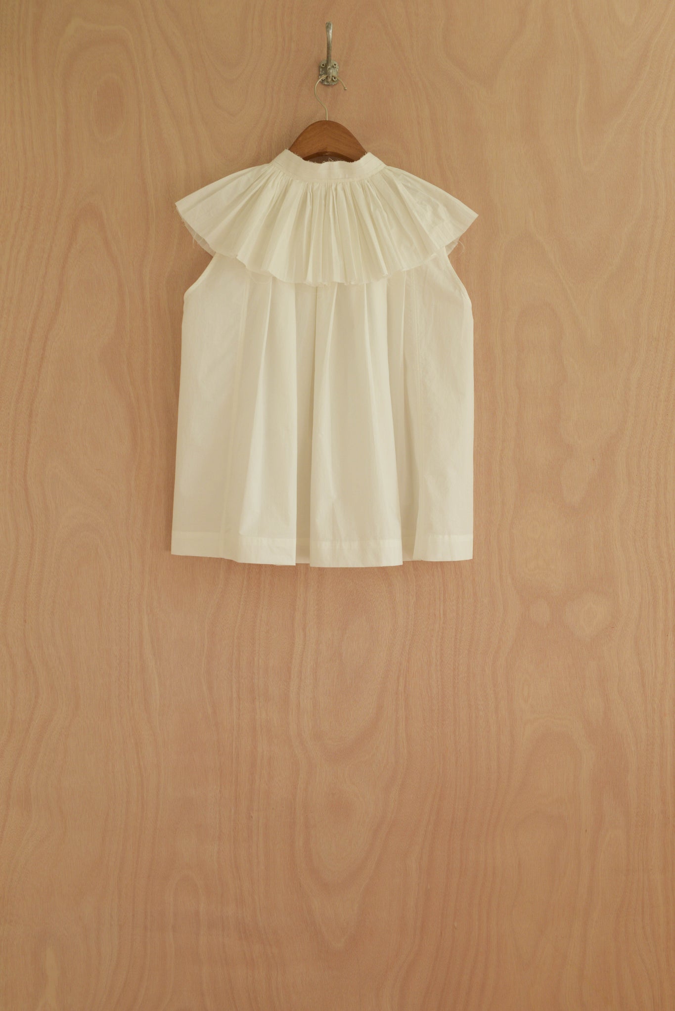 Back view of Rea Top in white, featuring structured pleats for volume.