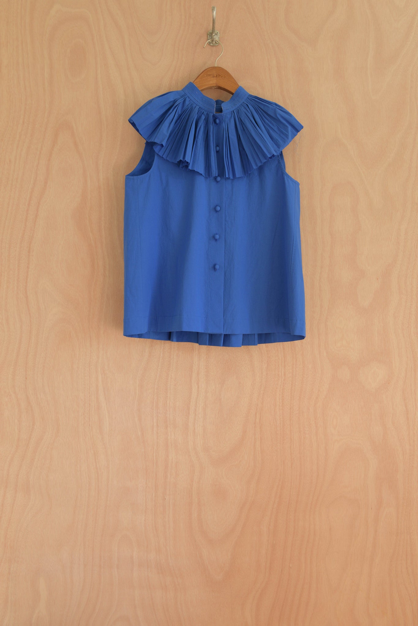 Rea Top in blue, organic cotton with a structured pleated collar and sleeveless design