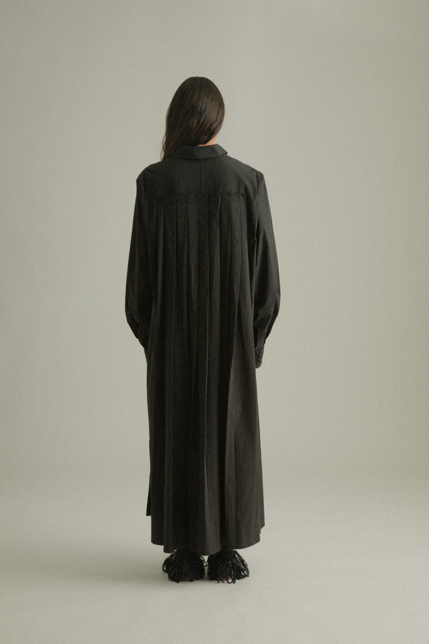 Back view of Sylvie Coat, featuring signature pleats for movement and elegance.