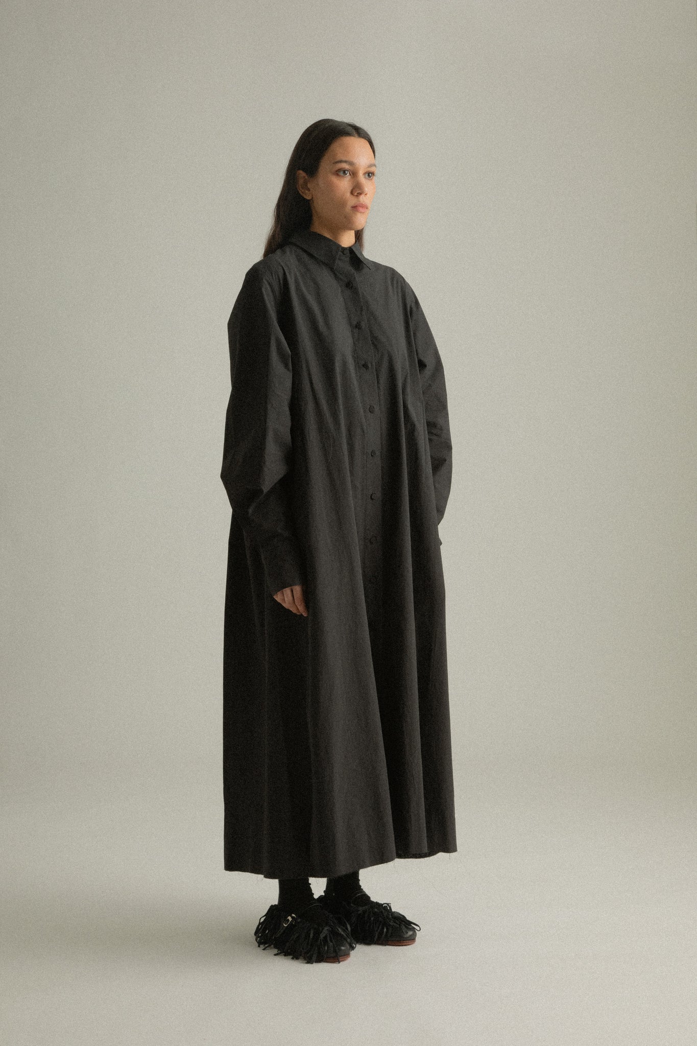 Side view of Sylvie Coat, emphasizing the flowing silhouette and organic cotton texture.