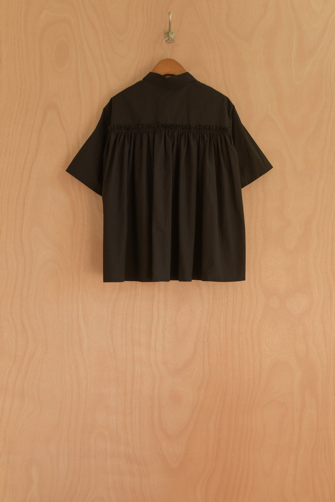 Back view of Wei Top in black, featuring gathered pleats for volume.